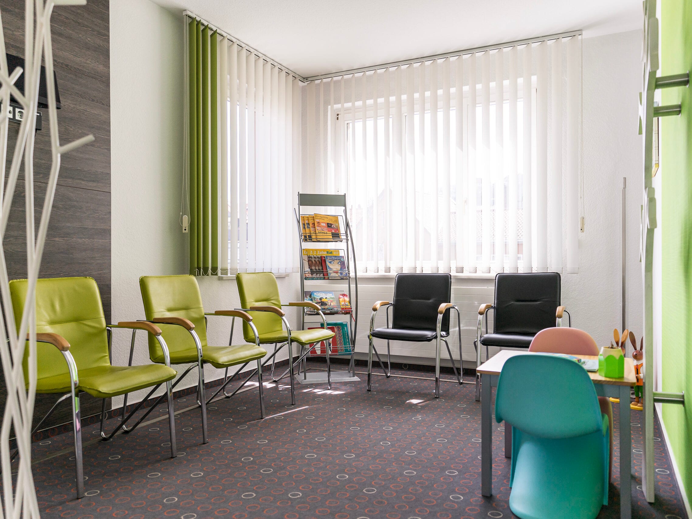 Wartezimmer mit Stühlen und Spielzeug.