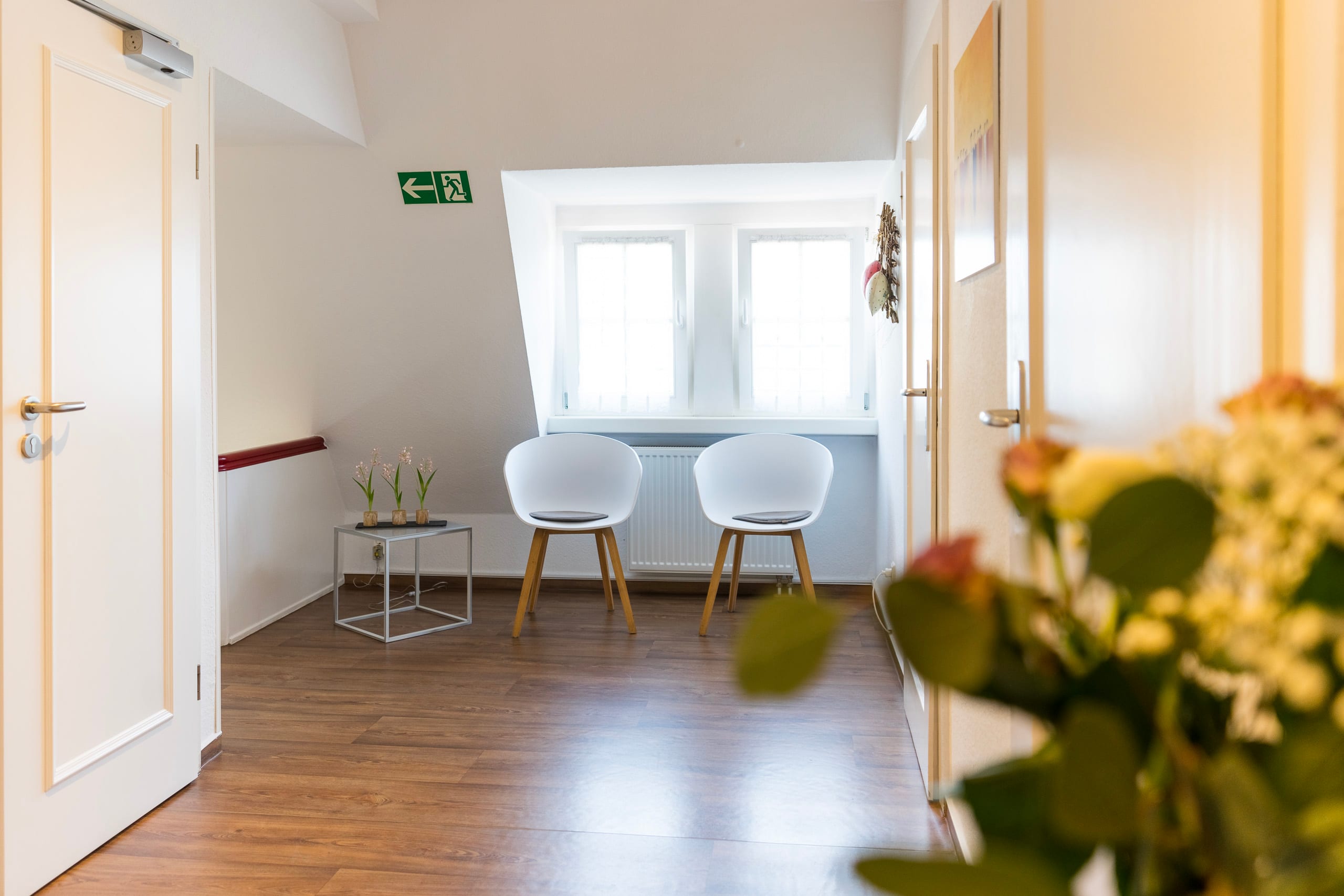 Warteraum mit zwei Stühlen und einem Tisch.